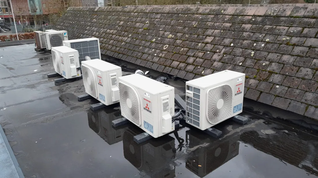 Meerdere airco-buitenunits op een plat dak van een bedrijfspand