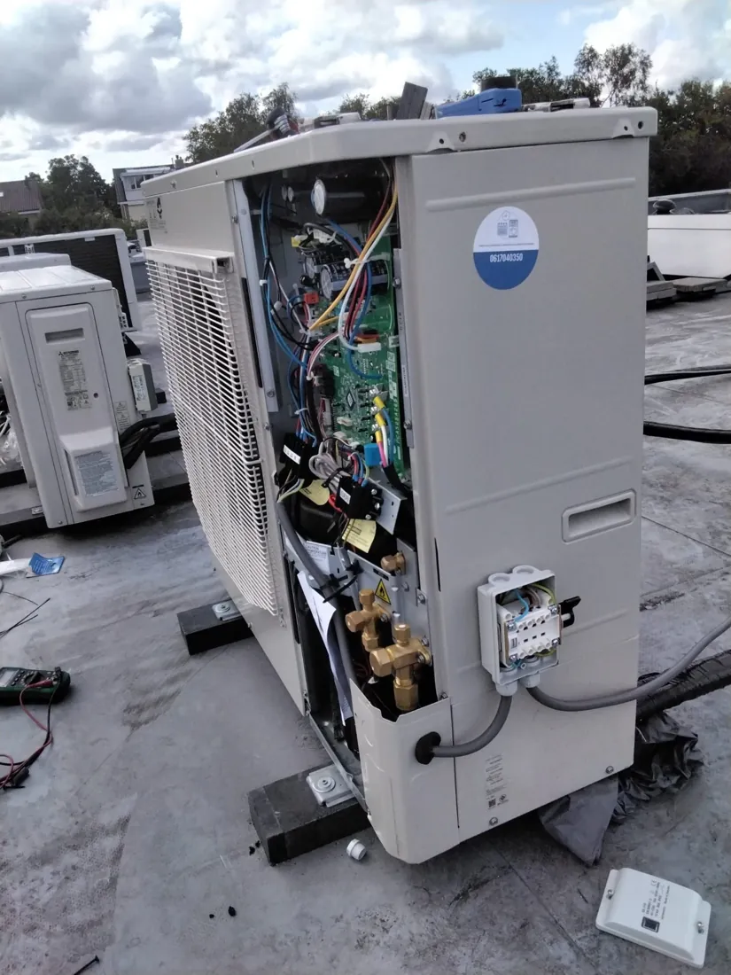 Geopende airco-unit tijdens vakkundig onderhoud aan het leidingwerk